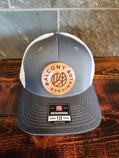 Grey hat with a round Balcony Botanicals leather patch